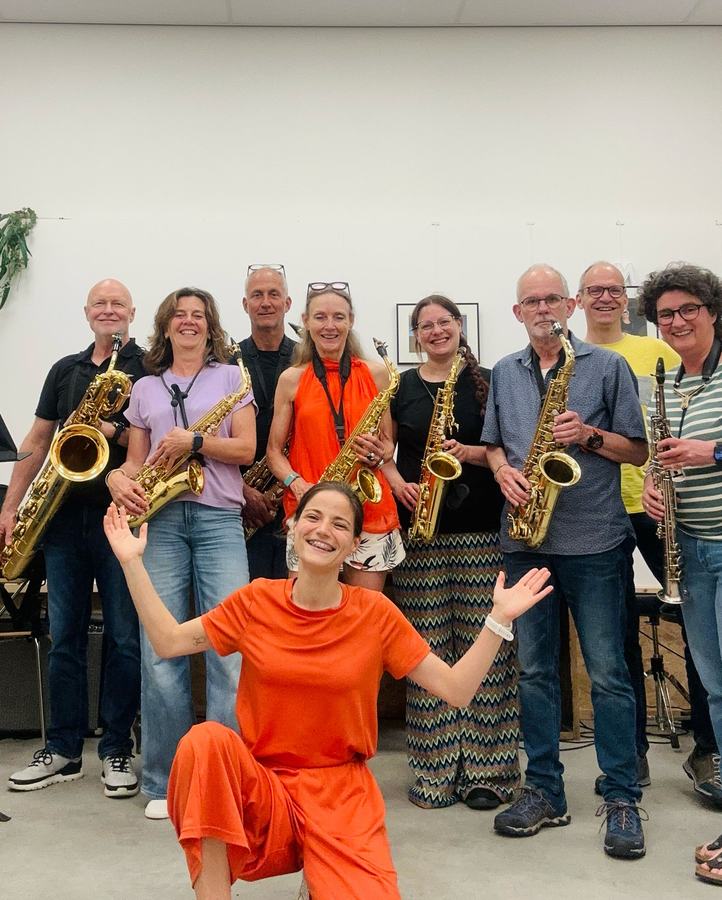 Saxofoonensemble poseert samen in de lesruimte