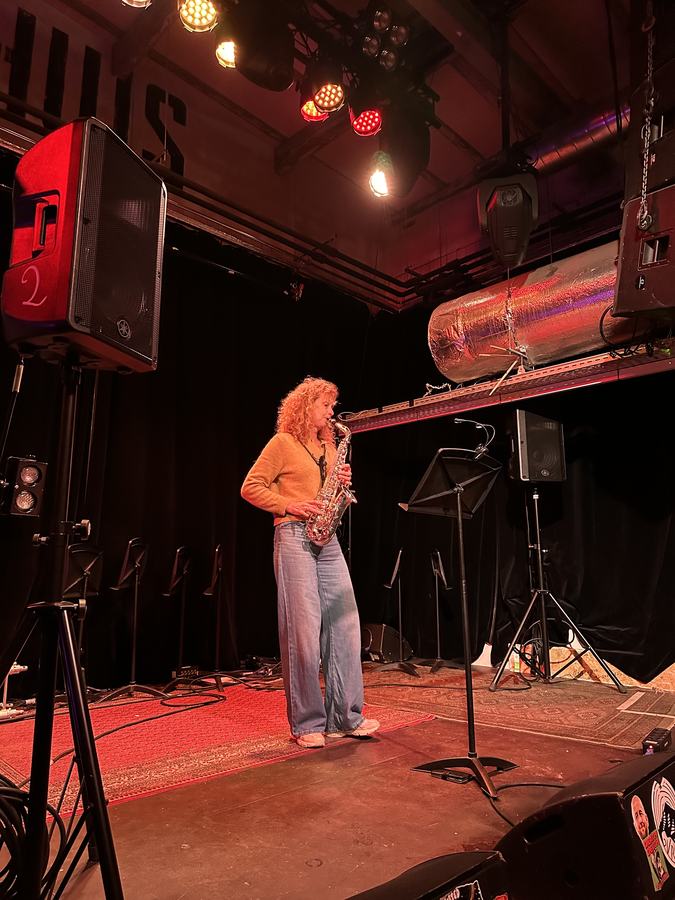 Saxofonist speelt solo op het podium onder warm licht