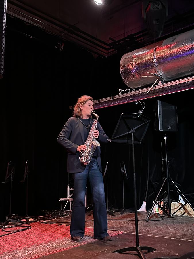Volwassen leerling speelt saxofoon op het podium